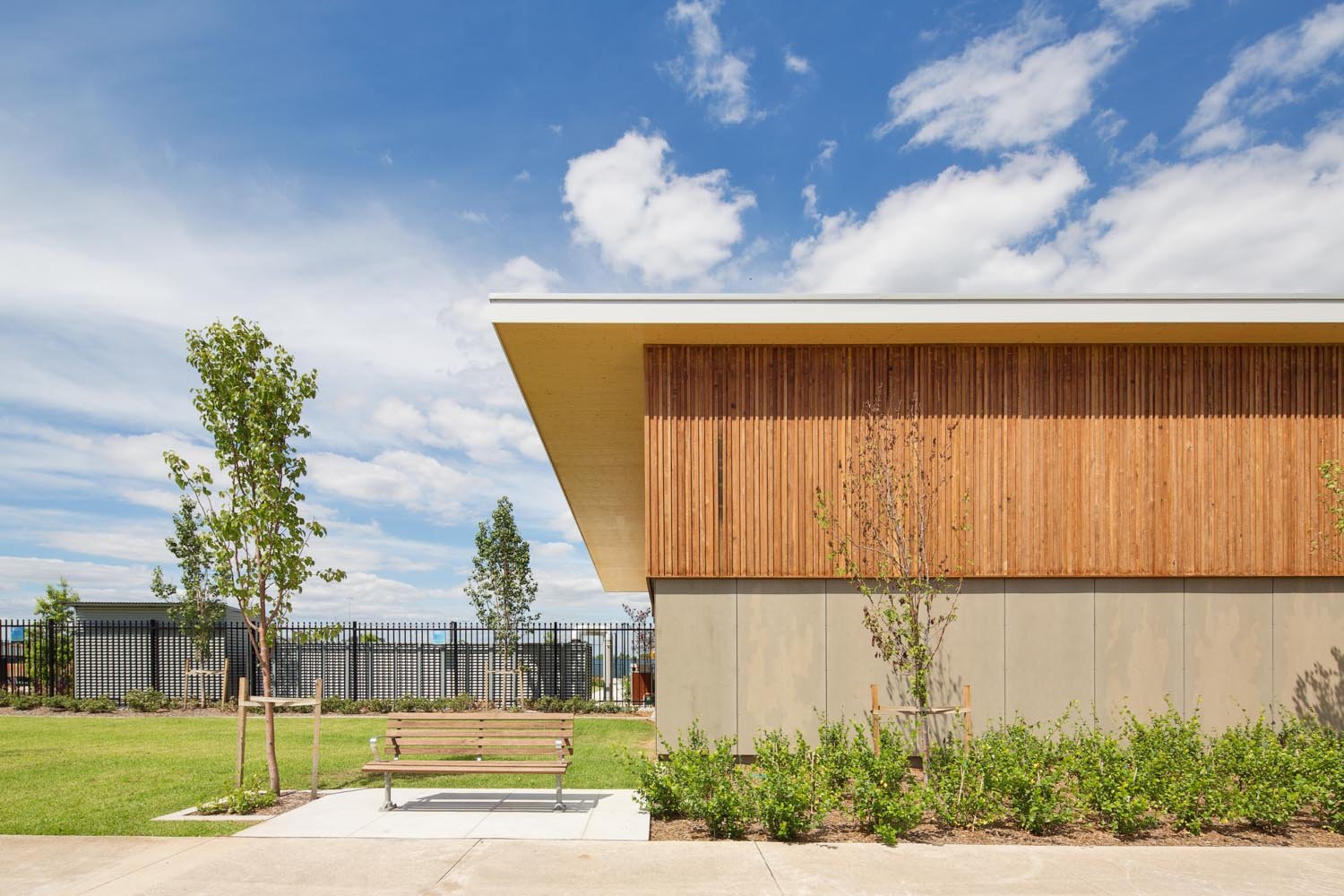 Timber-clad exterior of Jordan Springs Community Hub surrounded by landscaped grounds